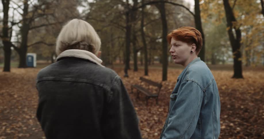 Lesbian couple wearing denim jackets meets up in the public park