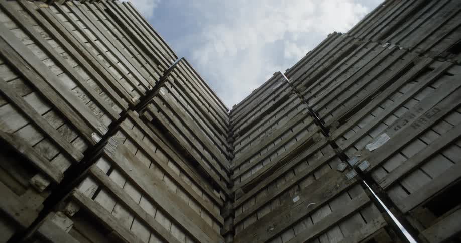 Wooden pallets piled up over each other under the sky