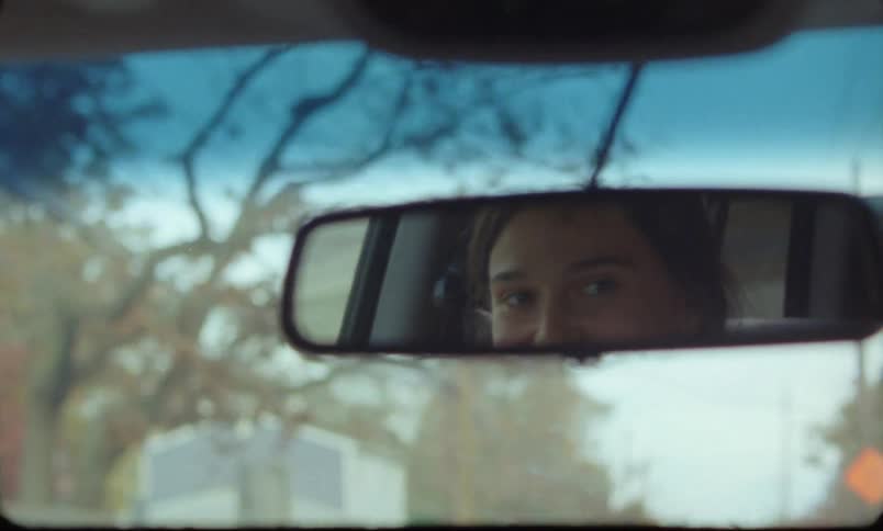 A young woman is driving a car in a small town