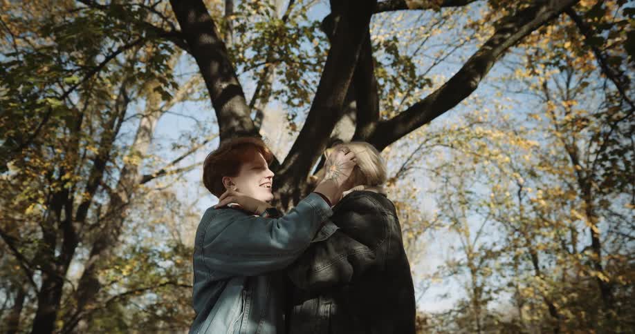 Two women throw leves and hug