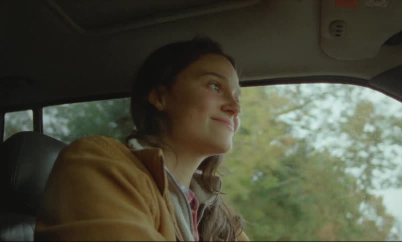 A woman smiles as she drives