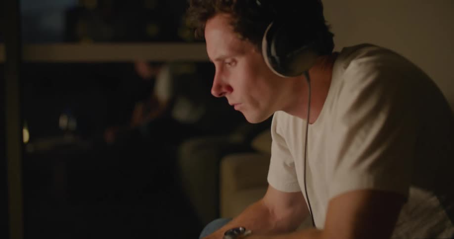A man is playing the keyboard on his laptop