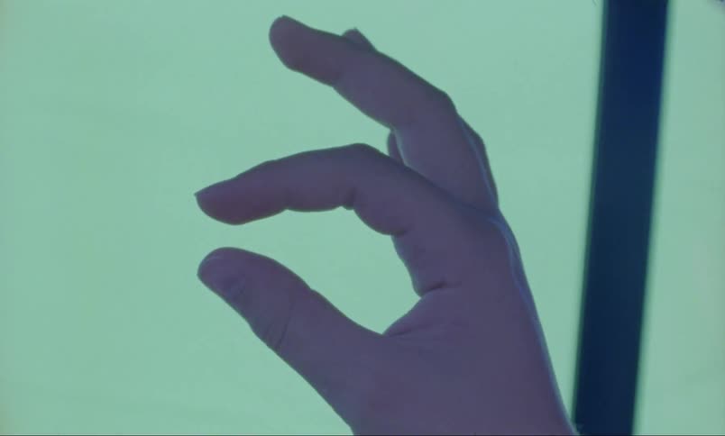 A person uses their thumb and forefinger to scrape something off a monitor
