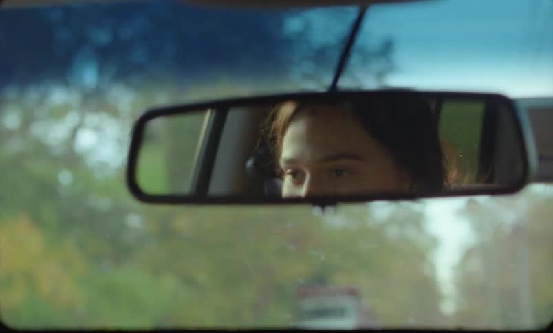 A woman is driving a car during the spring time