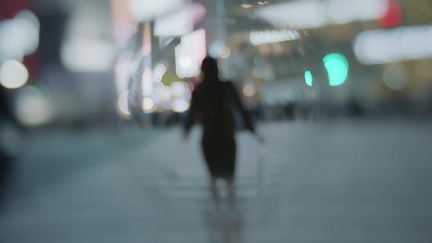 Out of focus fisheye lens footage of pedestrians crossing the street of a city