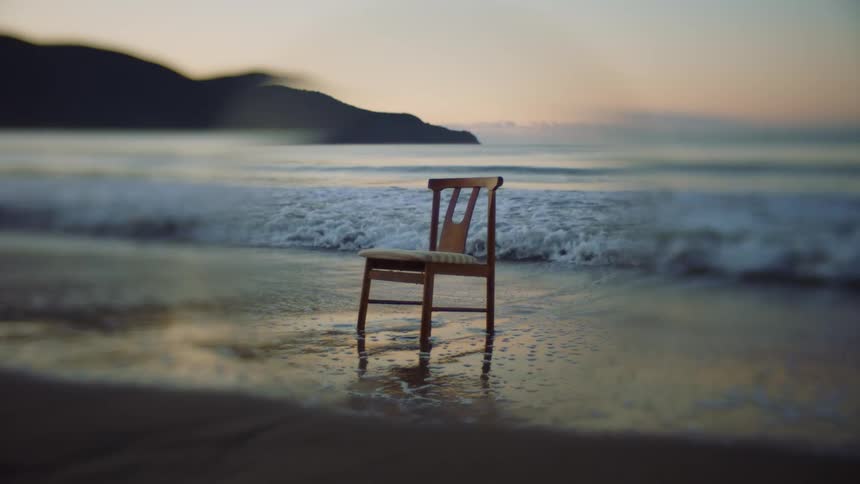 A chair is left on the coast of an ocean