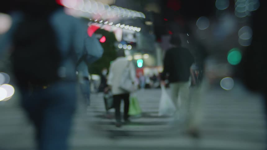 Pedestrians crossing a city street at night