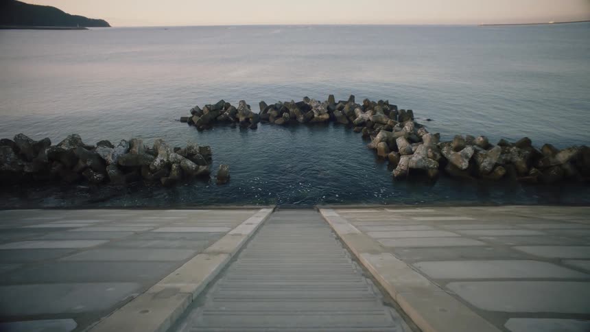 Small artificial bay at the end of a concrete staircase on the coast at evening