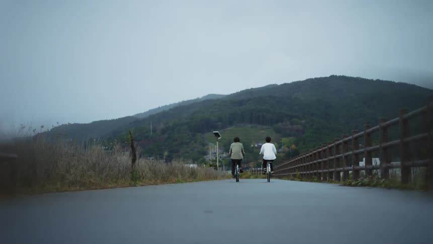 Two women are riding their bicycle