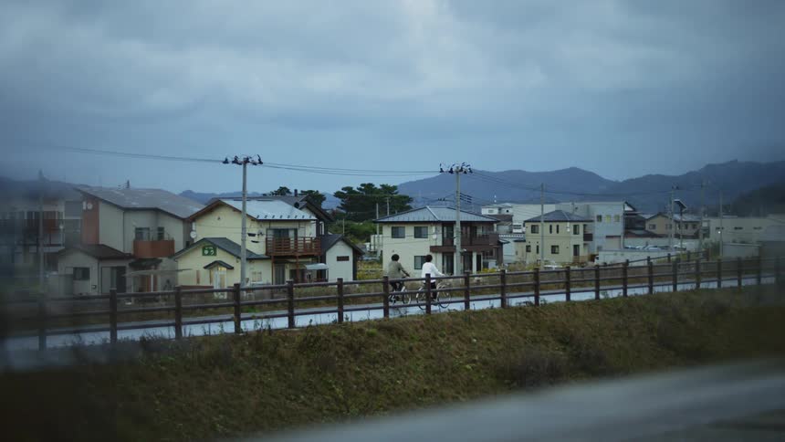 Couple riding bicycles on a road near a small town