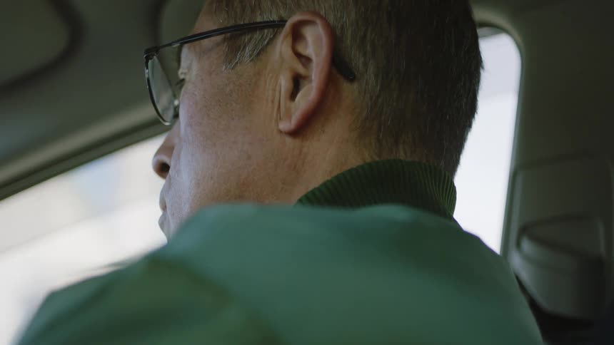 Close up view of a man driving a car during the daytime