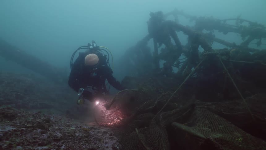 A person is exploring the bottom of the ocean floor