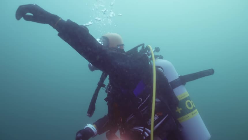 A scuba diver is waving underwater