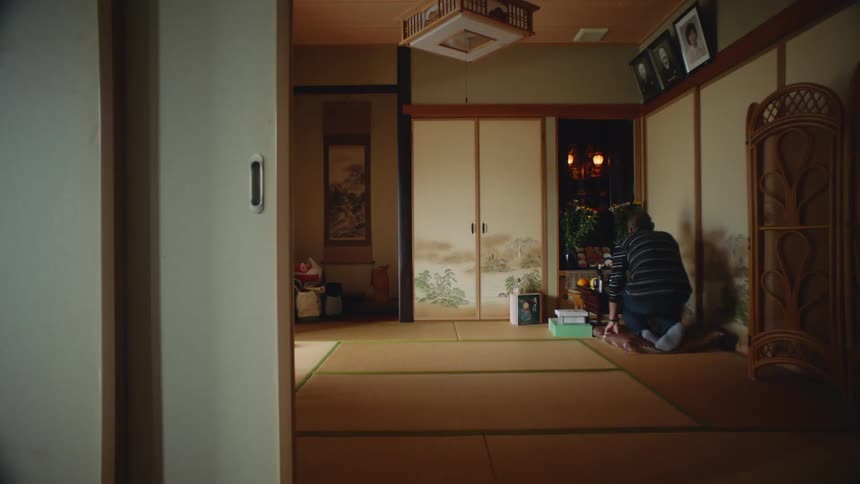 There is an older man that is sitting on the ground inside of his home
