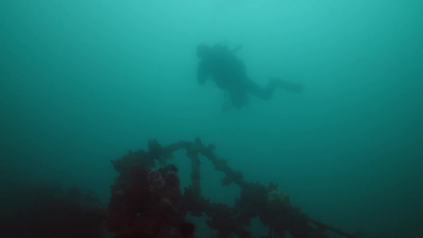 A scuba driver swims near the wreckage of a sunken ship