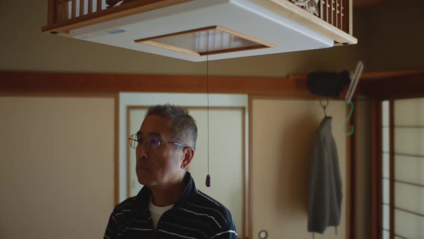 A man is standing indoors of his house