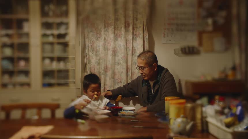 Father and son are sitting at the table inside of there home