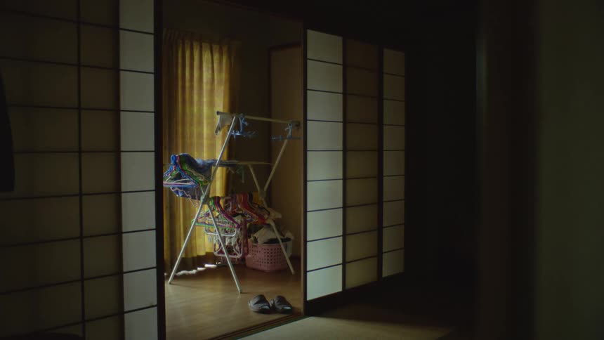 A drying rack filled with empty hangers on a room inside a japanese home