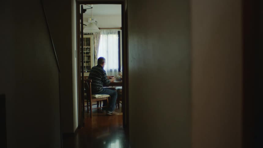 A man sitting at home at a dining table
