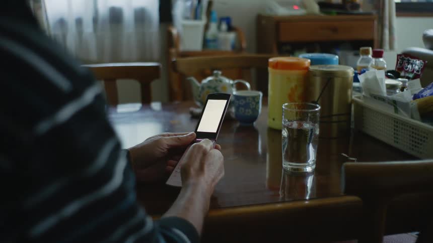 An older man is sitting down in a chair inside of his house