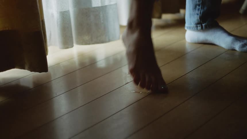 A person touching their bare foot to the floor and then lifting it back up