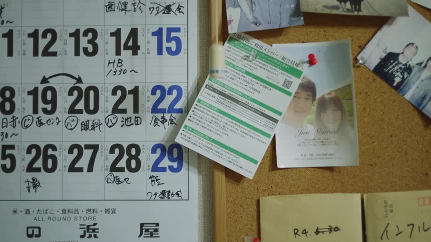 Close up of pictures and documents pinned to a cork board next to a calendar