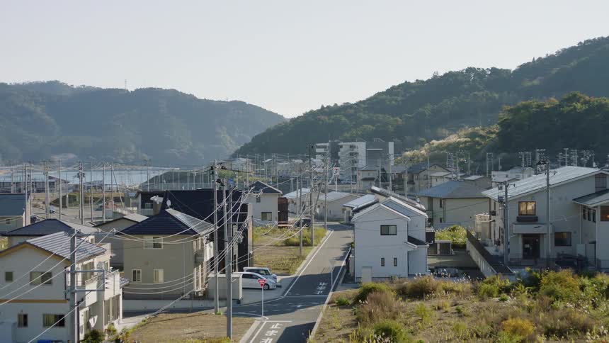 A small town in the valley of low mountains covered in forest during the day