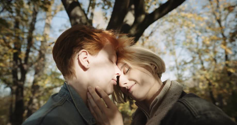 A young couple is outdoors and being affectionate with each other