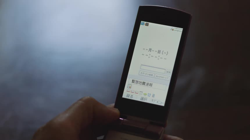 Close up of the screen of a flip phone with japanese characters