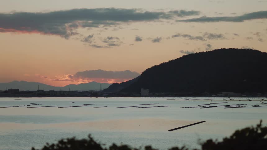 The sun is setting in the horizon of the lake