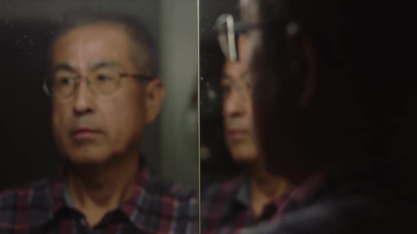 A man is looking at his reflection in a mirror