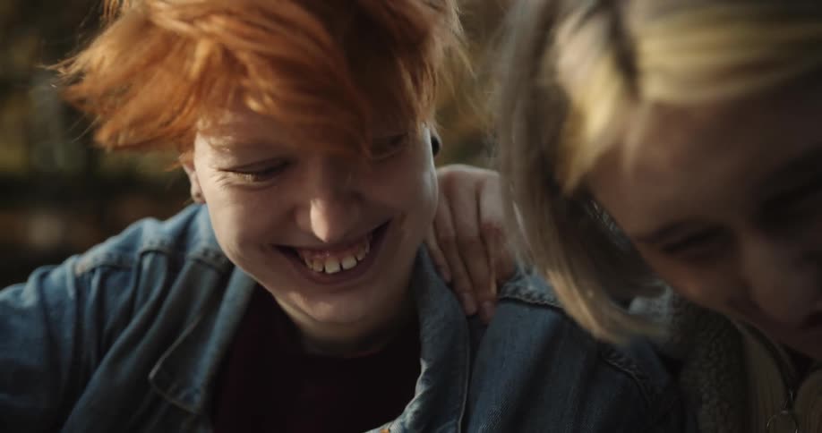 Two friends are celebrating and looking at a cellphone