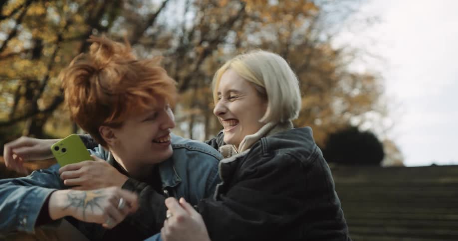 A young couple is sitting outside and being affectionate with each other