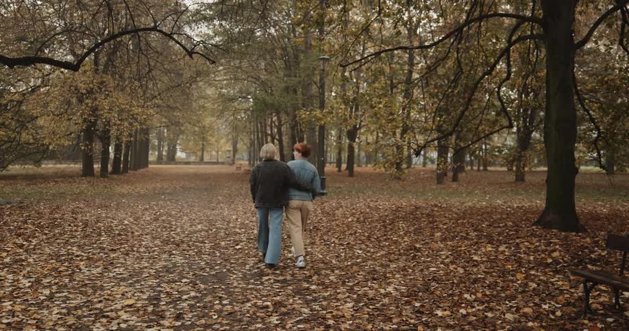 Young couple hugging by the waist walk together on the park