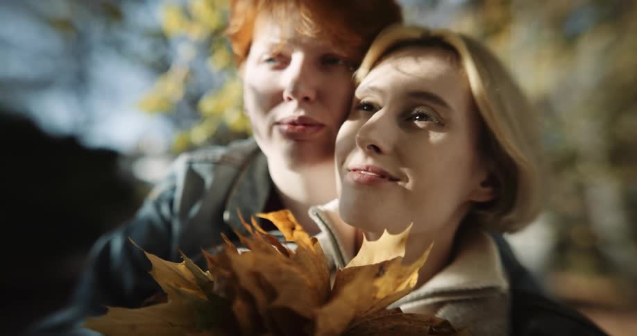 Two women outdoors in a forest during the fall