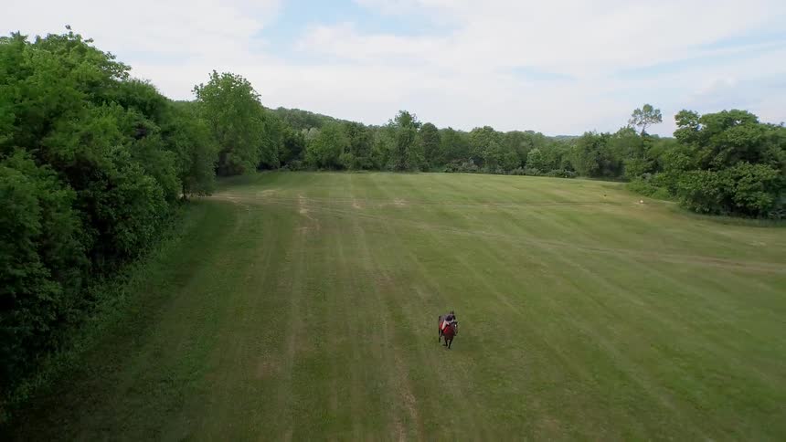 A person is riding a horse below on a large grass field