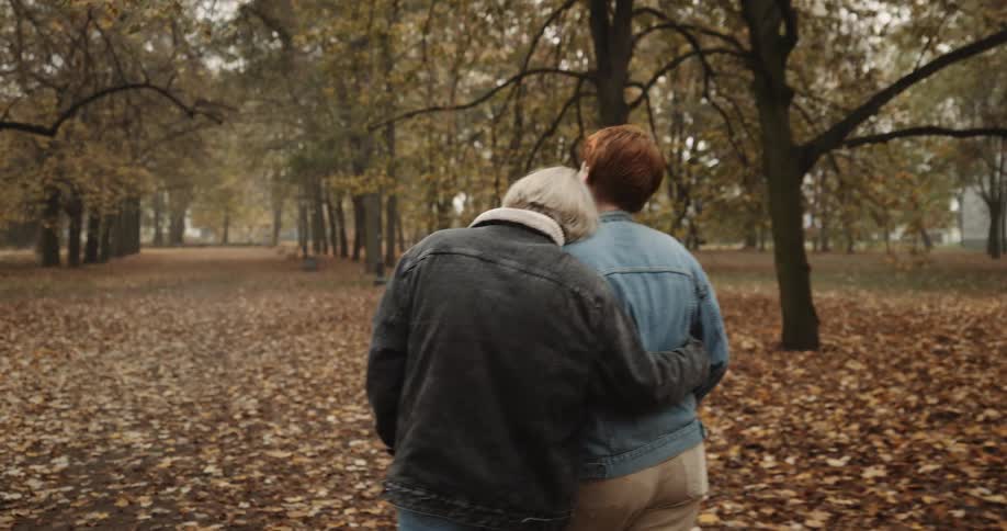 A young couple is walking outside in the nature area