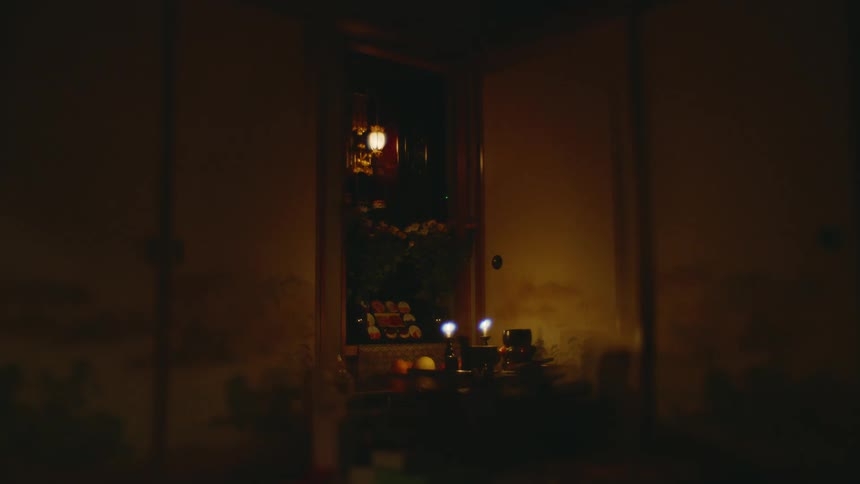 Lights shine on home shrine in dimly lit room