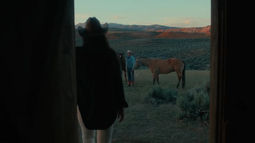 Two people are on a ranch with some horses