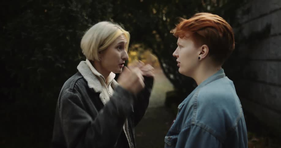 Two women argue then one of the two walks off along path angry