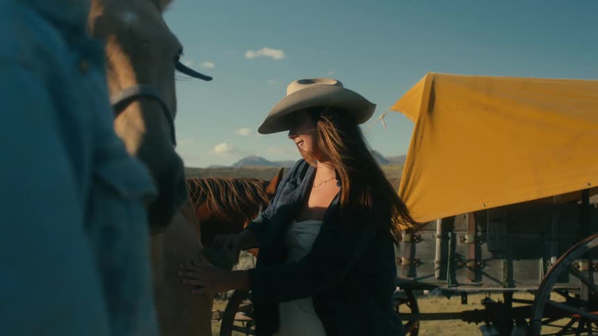 A woman is outdoors and brushing her horse