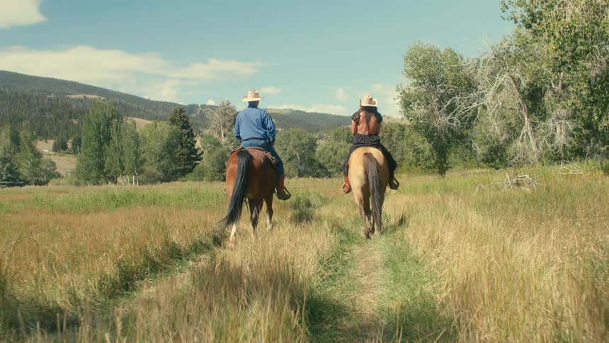 Man and woman are riding horses during the spring
