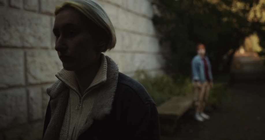 A woman yells at and shoves another woman before walking away leaving the other woman to sit down with her face in her hands