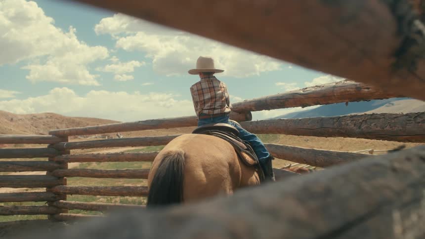 A young kid is riding a horse outside in the day time