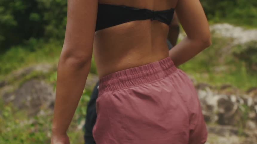 A young couple is walking outside in the forest