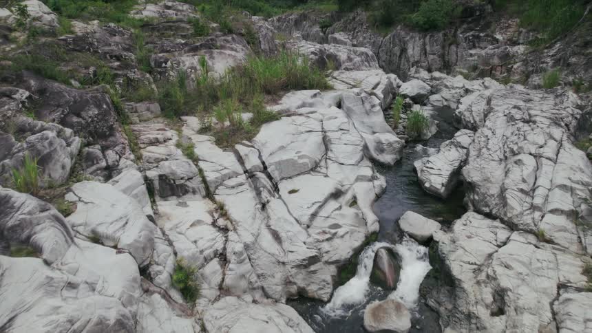 An aerial view of a river flowing through rocky terrain in the wilderness