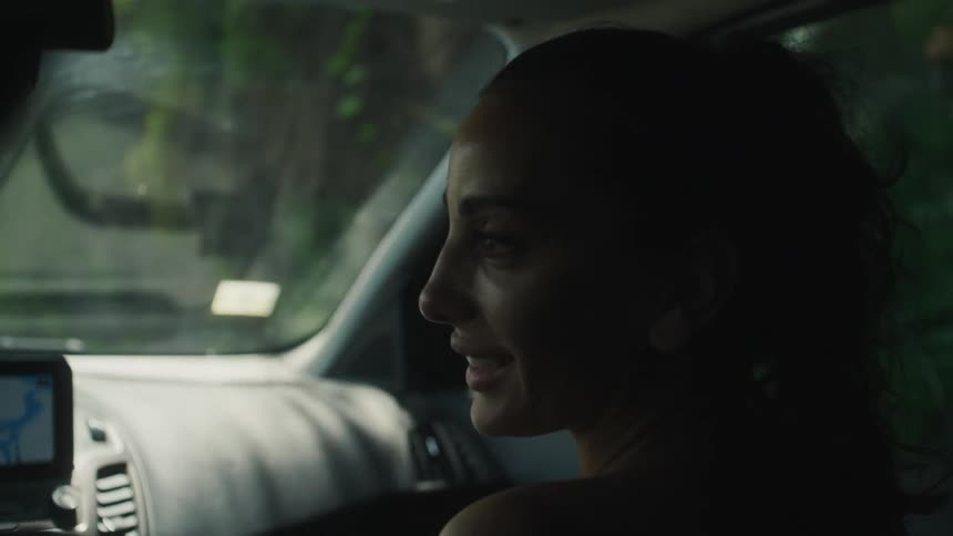 A woman is a passenger in a moving vehicle
