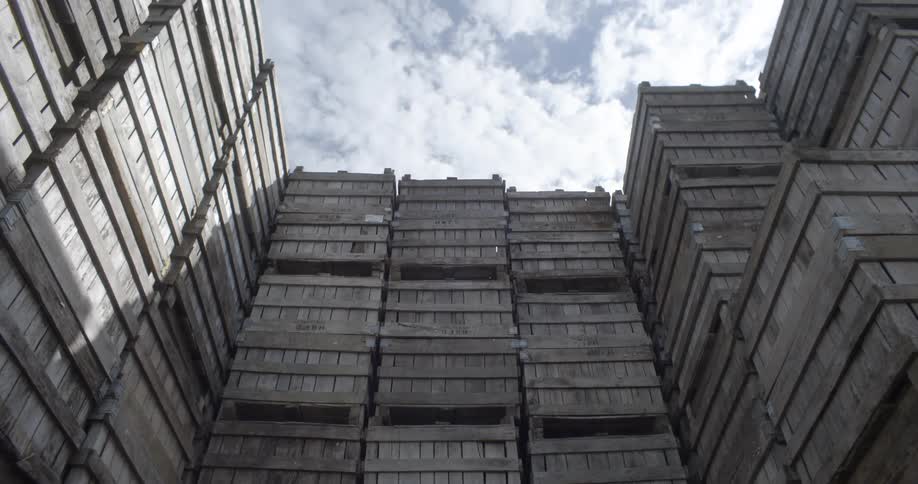 Wooden pallets piled up over each other under the sky