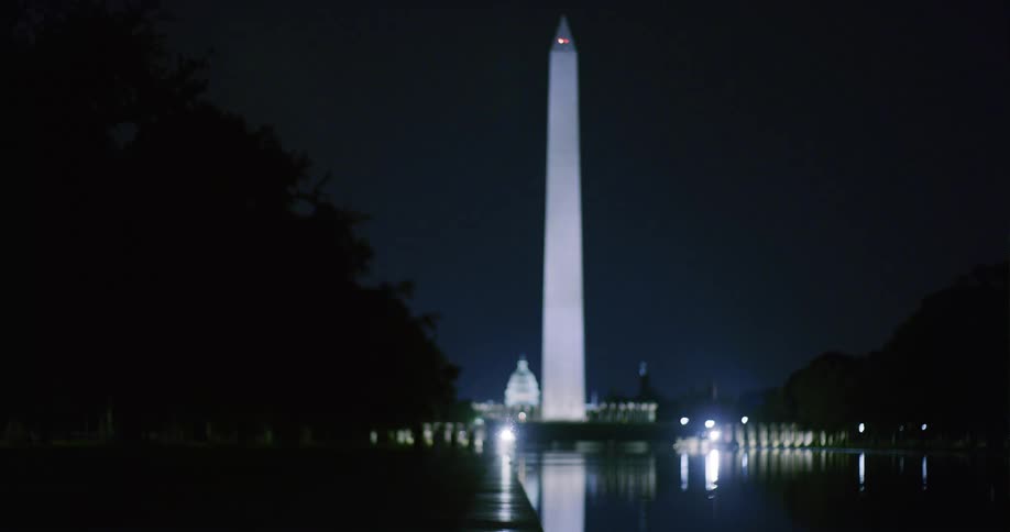 The washington monument with lights shining at night