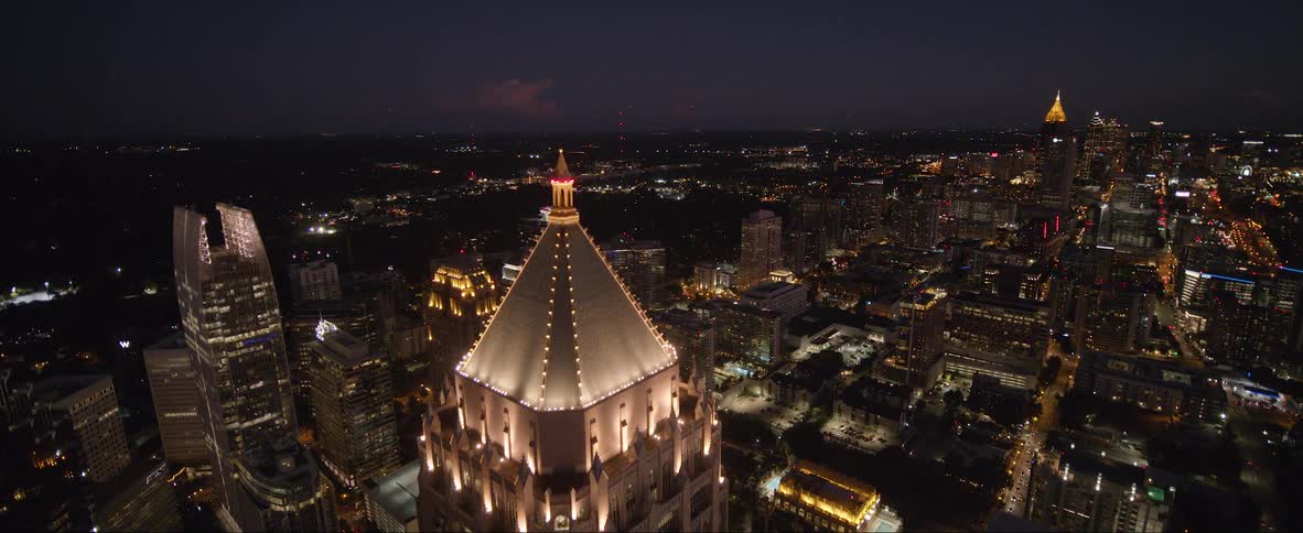 Aerial view of illuminated skyscrapers and buildings at night in the city